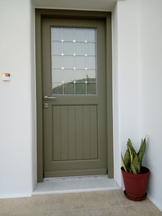 Πόρτα εξωτερική, με σιδεριά, σταθερό τζάμι και σκιάδιο.
